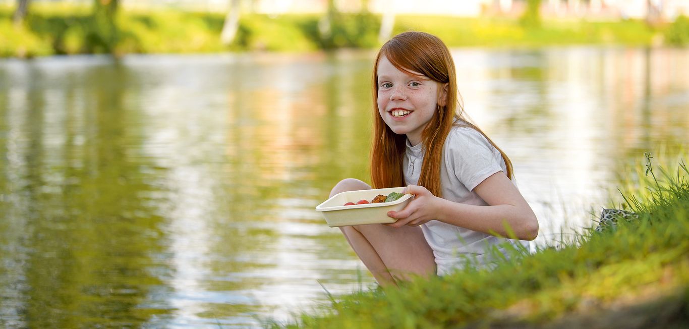 girl near the lake with a fibertray in her hand