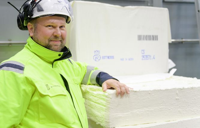 Man som lutar sig mot massabalar